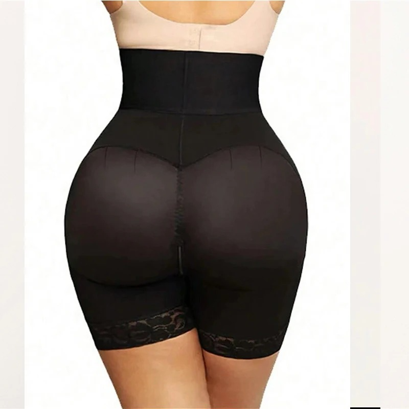 Woman wearing a black waist trainer with lace details on a plain background