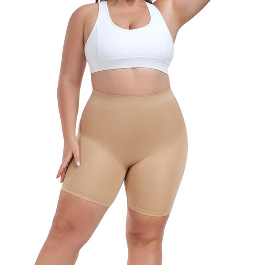 Person wearing beige shapewear shorts and a white sports bra on a white background
