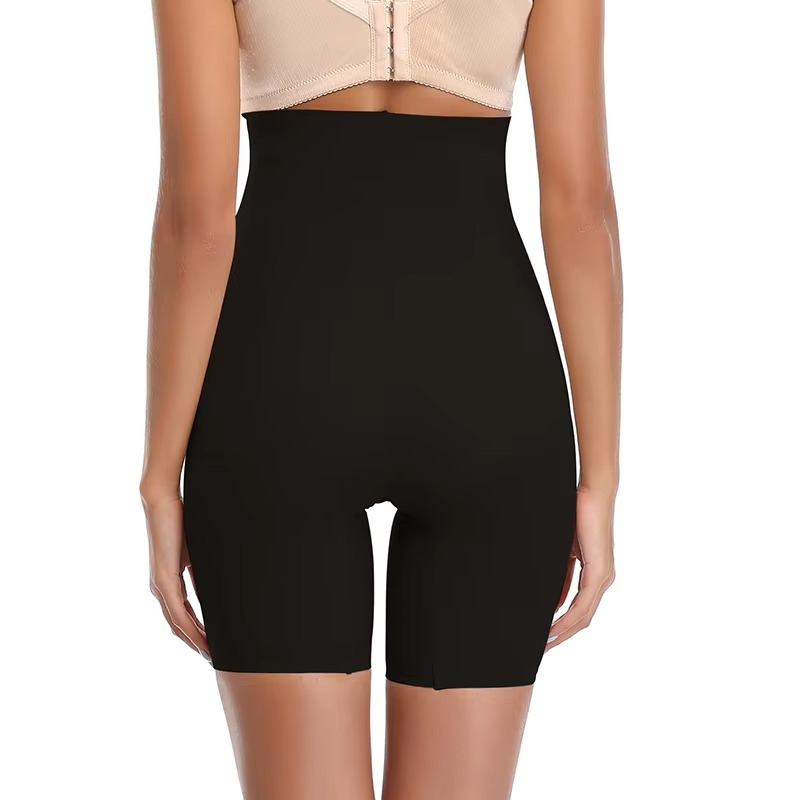Black shapewear shorts worn by a model on a white background