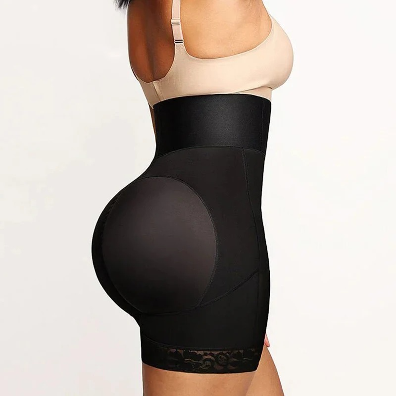 Woman wearing a black waist trainer with lace details on a plain background